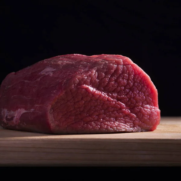 Closeup Piece Fake Sirloin Wooden Board Isolated Black Background — стоковое фото