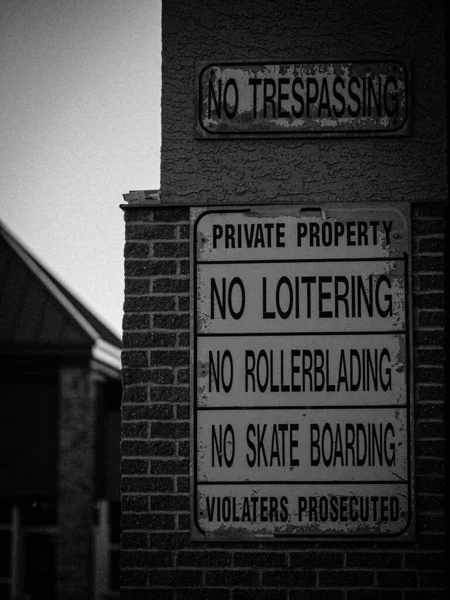 Grayscale Trespassing Signes Loitering Rollerblading Skate Boarding Side Brick Wall — Stock Photo, Image