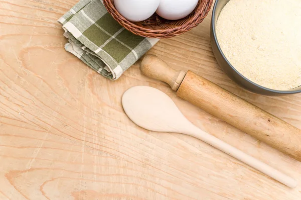 kitchen tools white eggs and dark gray bowl with wholegrain flour on worn wooden background with copy space