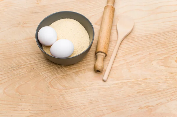 キッチンツール白い卵とコピースペースと木製の背景に全粒小麦粉と濃い灰色のボウル — ストック写真