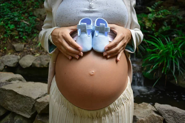 Young Pregnant Woman Holding Blue Baby Shoes Her Belly — Stock Photo, Image