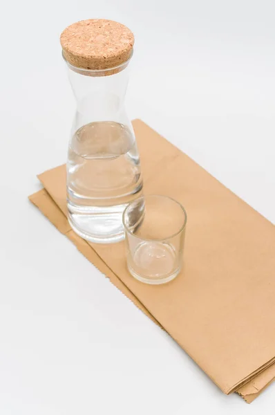 Γυάλινη Φιάλη Γεμάτη Καθαρό Νερό Λευκό Φόντο Και Χαρτί Τροφίμων — Φωτογραφία Αρχείου