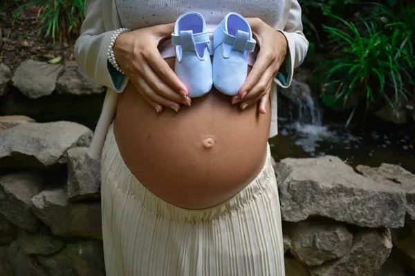 Young Pregnant Woman Holding Blue Baby Shoes Her Belly — Stock Photo, Image