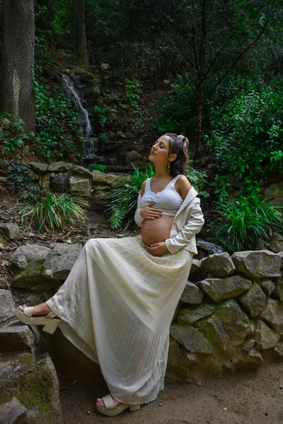돌벽에 기대어 자연스럽게 포즈를 취하는 아름다운 임산부 — 스톡 사진