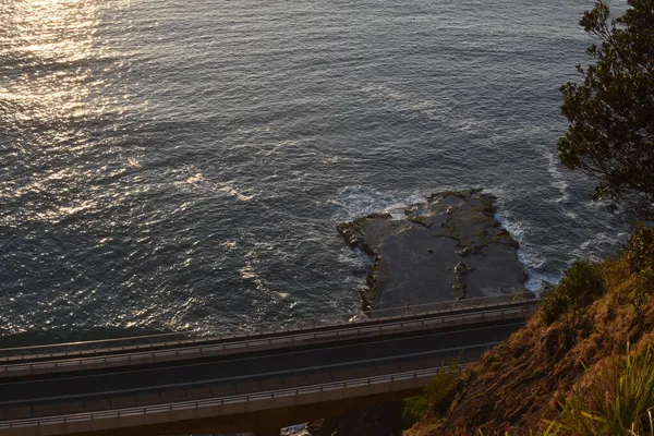 明るい太陽の下で海に囲まれた道路の無人偵察機ビュー — ストック写真