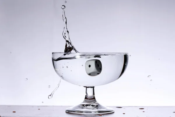 Ein Würfel Der Einem Glasbecher Ins Wasser Fällt Und Spritzer — Stockfoto