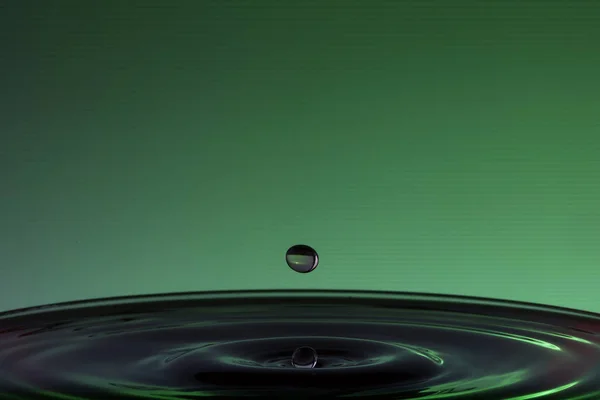 Een Plons Een Groen Oppervlak Dat Resulteert Watersculpturen — Stockfoto