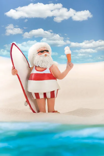 Zrelaksowany Mikołaj Idzie Surfować Stoi Brzegu Piaszczystej Plaży Jedząc Lody — Zdjęcie stockowe