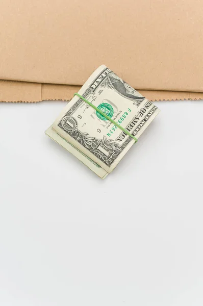Банкноты Долларах Сша Пачка Коричневая Бумага Белом Столе Текстовым Пространством — стоковое фото