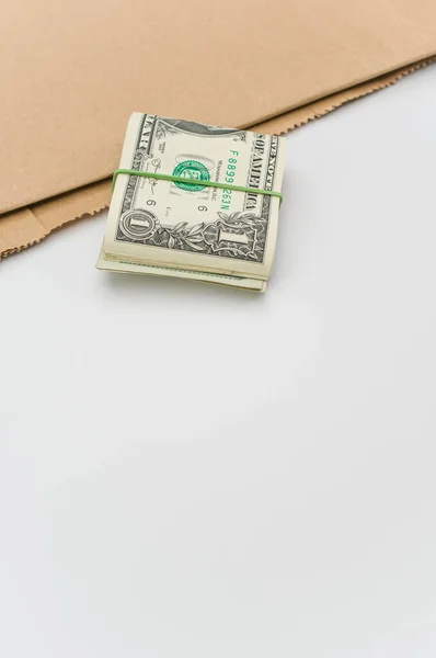 Банкноты Долларах Сша Пачка Коричневая Бумага Белом Столе Текстовым Пространством — стоковое фото