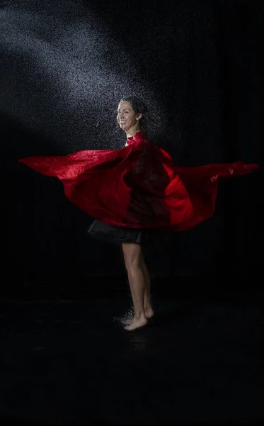 黒いドレスを着た濡れた髪をしたダンサーが水を楽しんで赤いスカーフで踊る — ストック写真