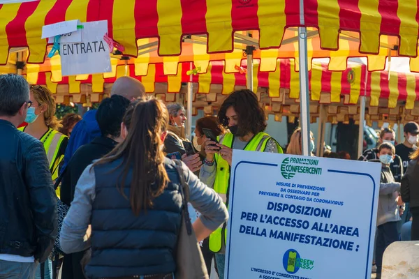 2021年10月17日 意大利 伯加莫 一名妇女在公众活动的入口处打电话询问Covid 19疫苗接种情况 — 图库照片