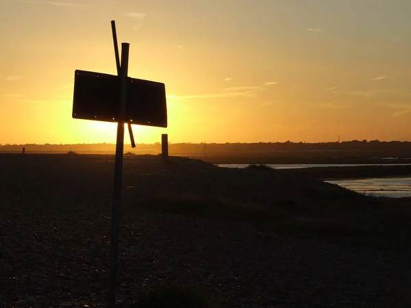 Sylwetka Znaku Brzegu Jeziora Podczas Pięknego Zachodu Słońca Wieczorem — Zdjęcie stockowe