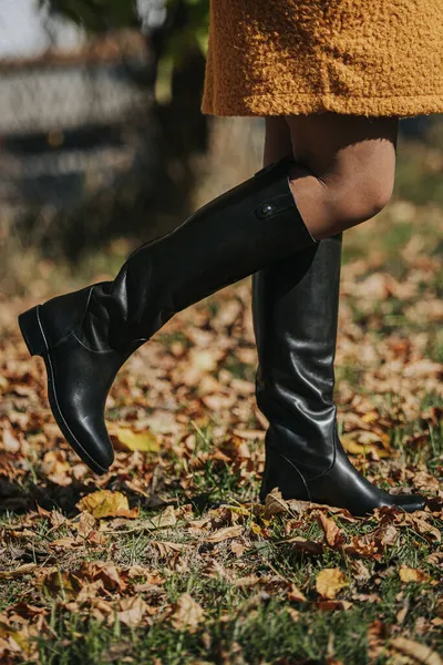 Sonbahar Yaprakları Üzerinde Yürürken Siyah Şık Çizmeler Giyen Bir Kadın — Stok fotoğraf
