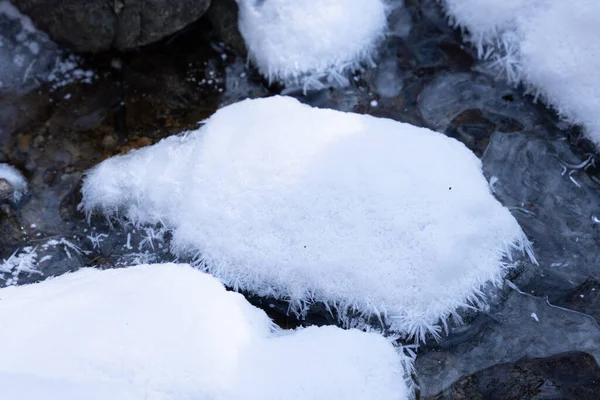 森林中被雪覆盖的河流中的石墙 — 图库照片