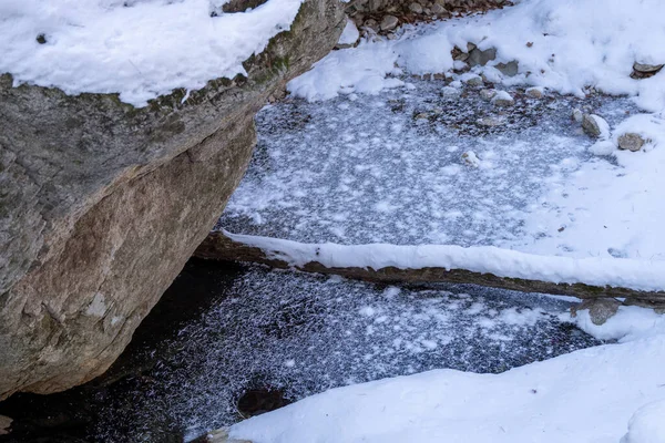 森の中の雪に覆われた川の石の塊 — ストック写真