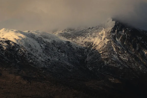 Bulutlu Gökyüzünün Altında Karlı Bir Dağ Sırası — Stok fotoğraf