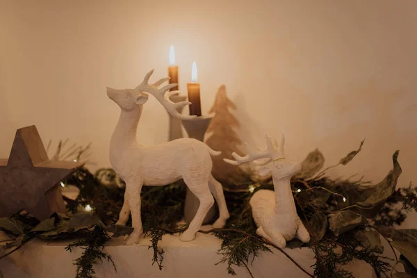 クリスマスや冬の休日のために暖炉の上に配置装飾的な鹿 キャンドルや装飾品 — ストック写真