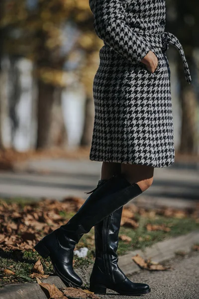 穿着黑色时髦靴子的女人 走在秋天的树叶上 — 图库照片