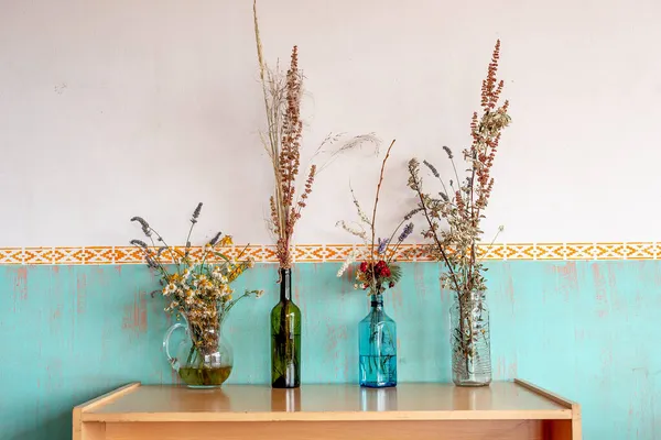 Tahta Bir Masanın Üzerinde Farklı Çiçeklerle Dolu Dört Vazonun Yakın — Stok fotoğraf