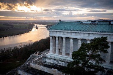 A scenic shot of the Walhalla memorial in Germany and a lake that goes in front of it clipart