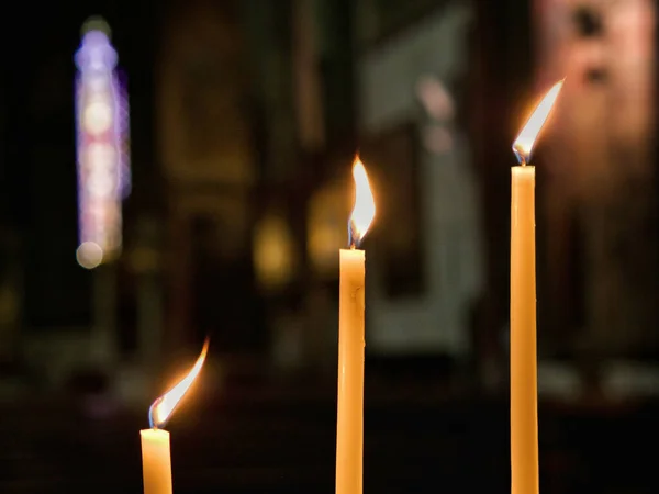 三支点燃的蜡烛在黑暗模糊的背景下选择性地聚焦在教堂里 — 图库照片#