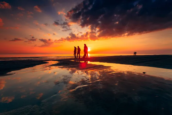 Una Silhouette Persone Che Camminano Sulla Costa Sabbiosa Del Mar — Foto Stock
