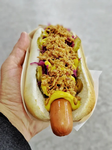 Een Verticaal Schot Van Een Hand Die Een Hotdog Vasthoudt — Stockfoto