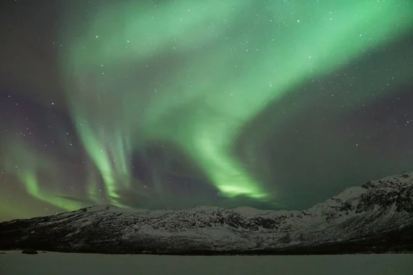 挪威北冰洋克瓦洛亚的一座雪山上闪烁着令人叹为观止的北极光 — 图库照片