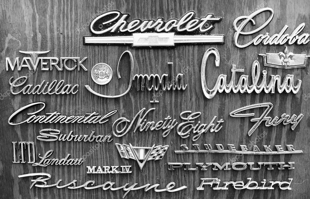 KANSAS CITY, UNITED STATES - Oct 11, 2021: A black and white shot of American car brand name badge logos attached to wooden wall as art in a bar