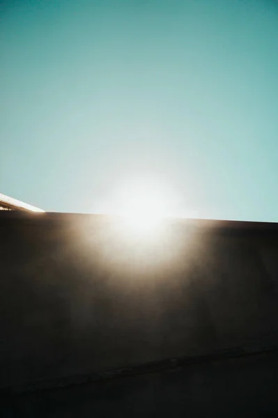 Een Verticaal Shot Van Lichtende Zonnestralen Een Blauwe Lucht — Stockfoto