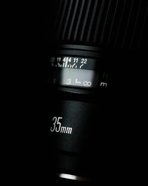 一个垂直拍摄的35Mm相机镜头隔离在黑暗的背景图上 — 图库照片