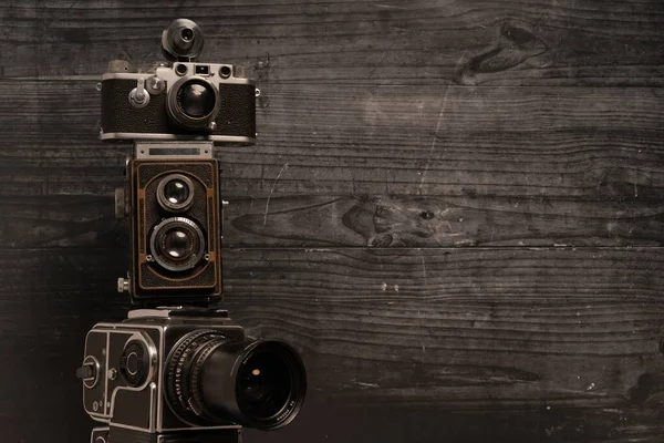 Três Câmeras Vintage Empilhadas Fundo Madeira Escura — Fotografia de Stock