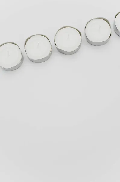 コピースペース付きの白いテーブルの上に白い香りのワックスティーライトの行 — ストック写真