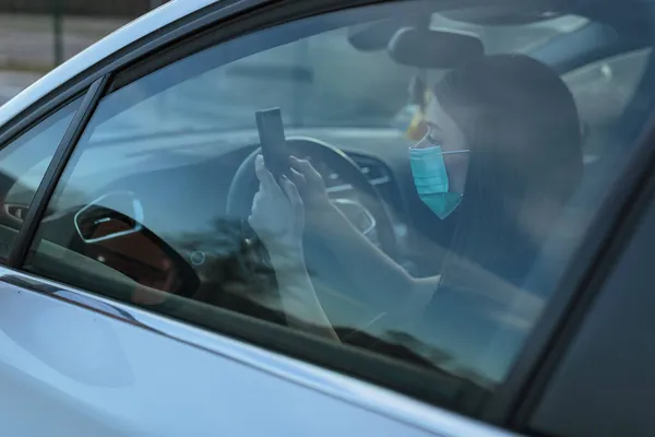 Vit Kvinna Ansiktsmask Med Mobiltelefon När Hon Kör Bil — Stockfoto