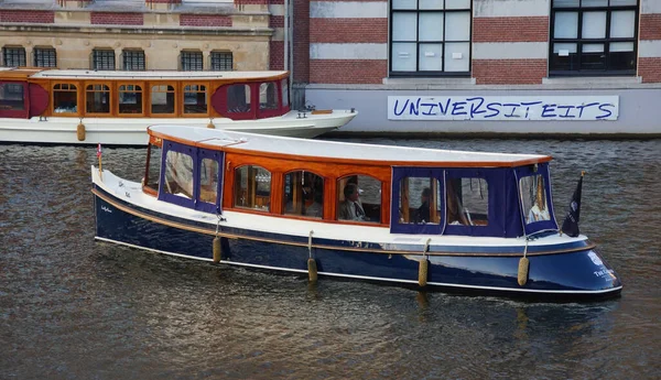 アムステルダム オランダ 2011年11月27日 オランダのアムステルダムの建物の背景に川で古いモータ船の美しい景色 — ストック写真