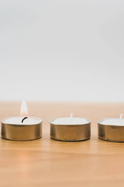 一排排白色的香蜡茶灯放在带有复制空间的木制台面上 — 图库照片