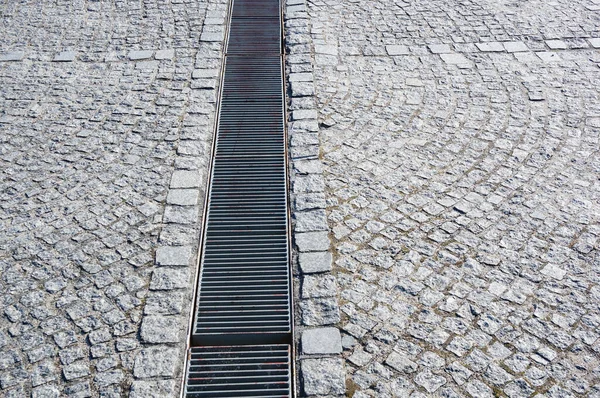 長い金属の錆びた雨の排水路と石畳の閉鎖 — ストック写真