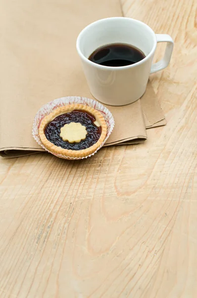 Schwarze Kaffeetasse Und Süßer Marmelade Cupcake Auf Einer Tischplatte Aus — Stockfoto