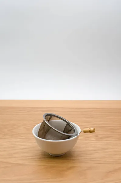 Tahta Zemin Üzerinde Seramik Bir Kasede Çay Yapraklı Metal Çay — Stok fotoğraf