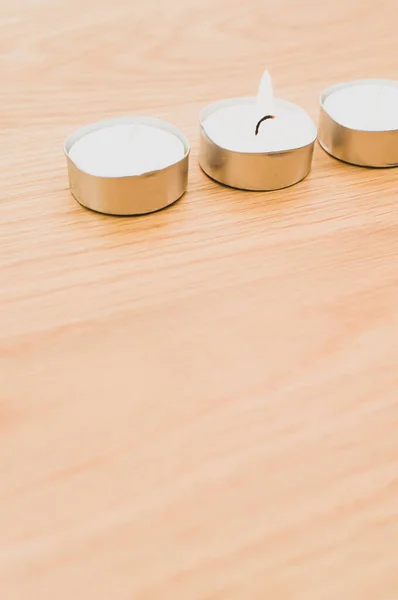 コピースペース付きの木製のテーブルの上に白い香りのワックスティーライトの行 — ストック写真
