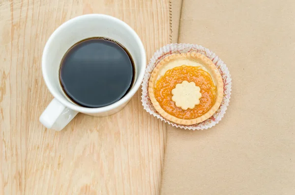 Schwarze Kaffeetasse Und Süßer Marmelade Cupcake Auf Einer Tischplatte Aus — Stockfoto