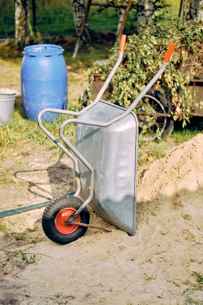 Eine Vertikale Aufnahme Einer Metallschubkarre Die Neben Einem Sandhaufen Steht — Stockfoto