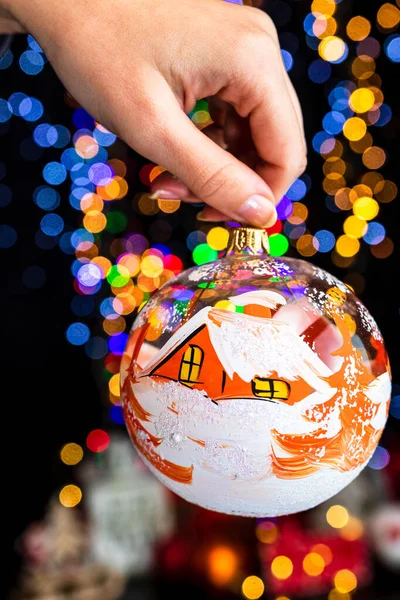 Female Hand Holding Christmas Decoration Ornament Christmas Tree Bokeh Background —  Fotos de Stock