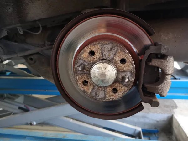 A shiny disc brake of a car in a garage