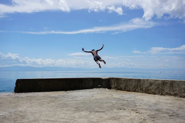 Male Jumping Sea Blue Sky Tiny Clouds — 图库照片