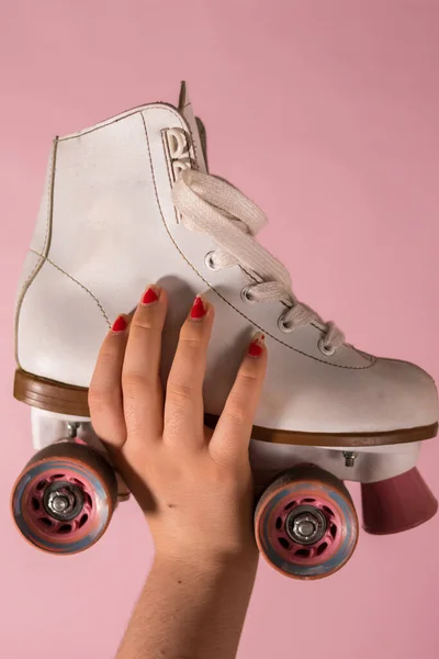 Hand Holding White Skates Pink Background — 图库照片