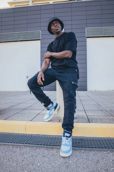 Vertical Shot Young Black Man Street Style Clothes Sitting Pillar — Stock Photo, Image