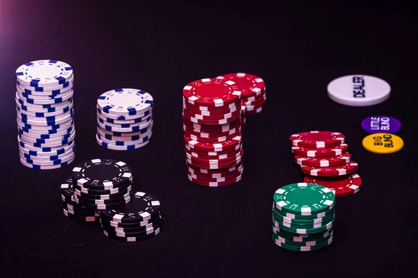 Poker Fişlerini Işıkların Altında Karanlık Bir Arkaplana Yakın Çekim — Stok fotoğraf