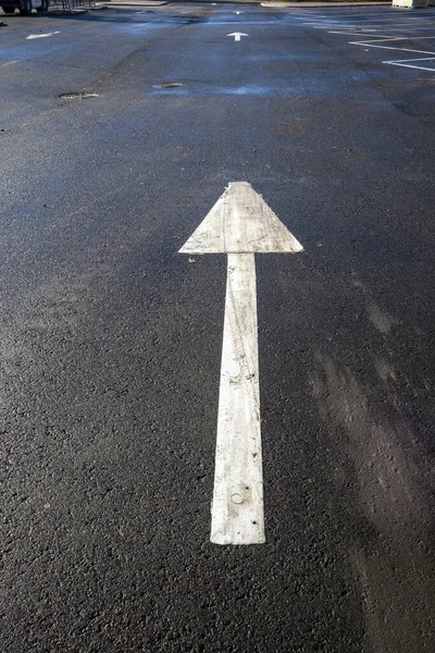 Disparo Vertical Una Flecha Direccional Blanca Estacionamiento —  Fotos de Stock